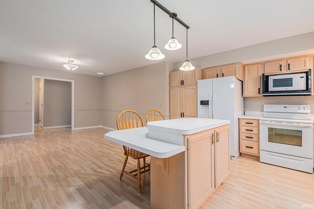 kitchen with a kitchen breakfast bar, light wood-type flooring, light countertops, light brown cabinets, and white appliances