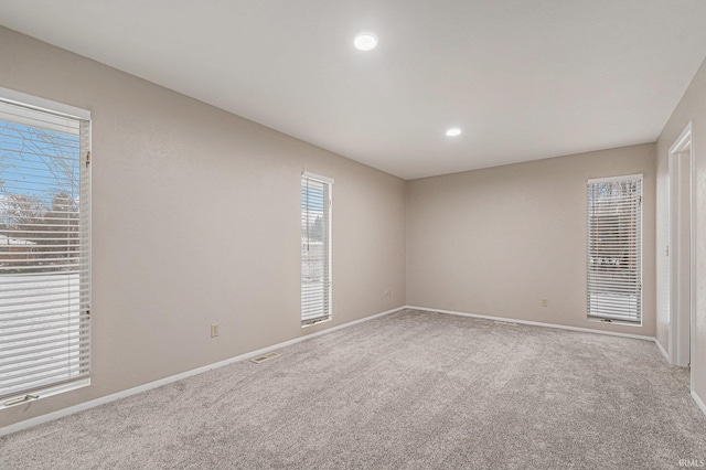 carpeted empty room with visible vents, recessed lighting, and baseboards