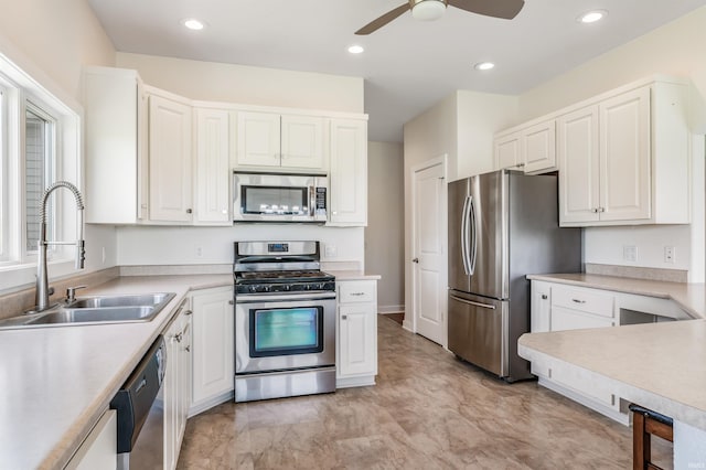 kitchen with light countertops, a sink, ceiling fan, and stainless steel appliances