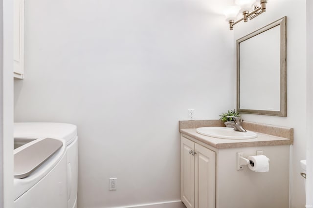 bathroom featuring vanity, washer and dryer, and toilet
