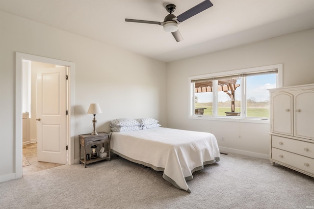 bedroom featuring a ceiling fan, baseboards, and light colored carpet