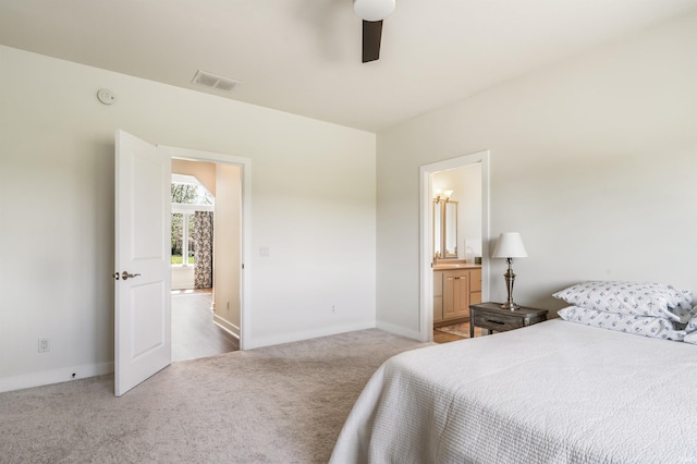 carpeted bedroom with baseboards, ensuite bathroom, ceiling fan, and visible vents