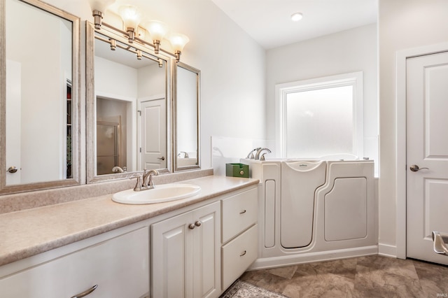 bathroom with vanity and a garden tub