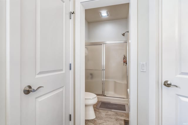 full bathroom featuring visible vents, a stall shower, and toilet