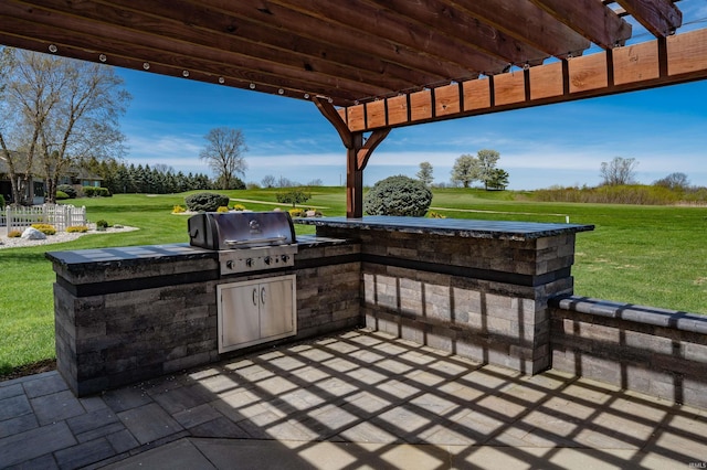 view of patio with an outdoor kitchen, view of golf course, and grilling area