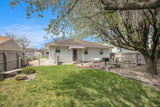 back of house with a yard, a fenced backyard, and a patio area