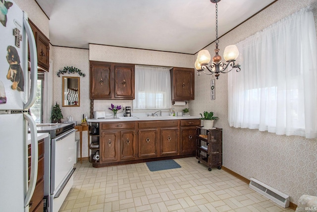 kitchen featuring white appliances, light countertops, a chandelier, wallpapered walls, and visible vents