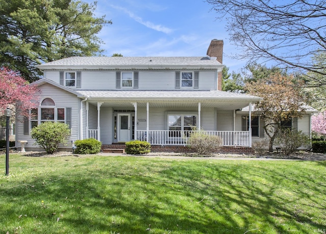 view of front of property featuring covered porch, a chimney, and a front lawn