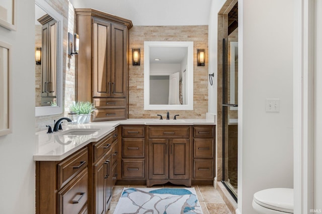 bathroom with a sink, a shower stall, backsplash, and toilet