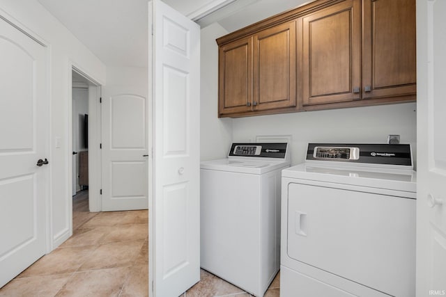 clothes washing area featuring cabinet space and washing machine and dryer