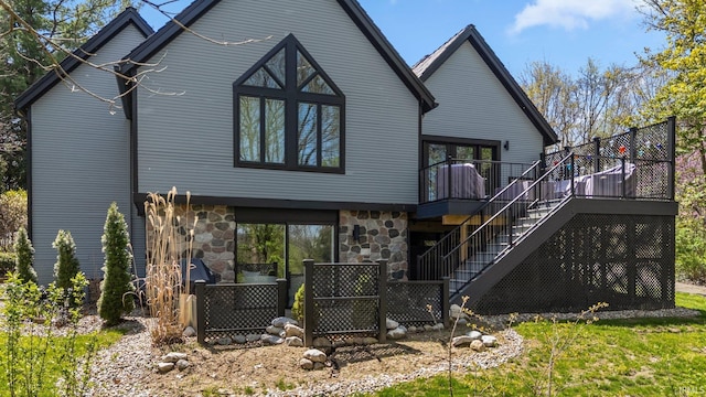 rear view of property featuring stairway, a wooden deck, and stone siding
