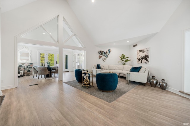living area with high vaulted ceiling, recessed lighting, baseboards, wood finished floors, and visible vents