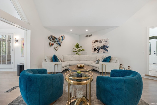 living area featuring light wood-style floors, visible vents, recessed lighting, and lofted ceiling