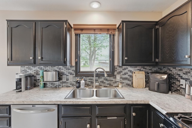 kitchen featuring range with gas cooktop, tasteful backsplash, dishwasher, a sink, and light countertops