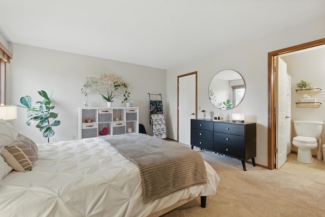 bedroom with ensuite bath and light carpet