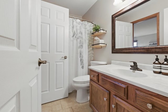 bathroom with toilet, tile patterned floors, and vanity