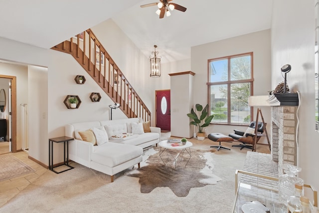 living room with stairs, ceiling fan, carpet floors, and baseboards