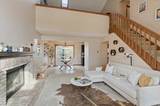 living area with an inviting chandelier, a high ceiling, a fireplace, and stairs