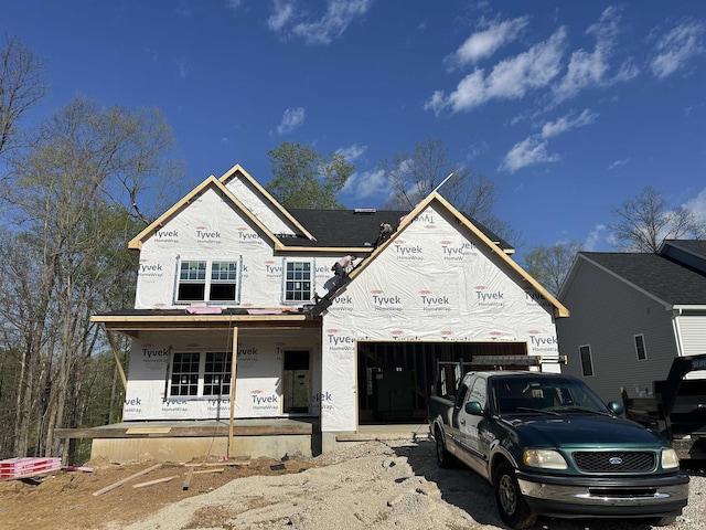 unfinished property with an attached garage, a porch, stucco siding, and aphalt driveway