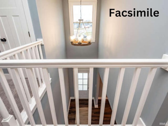 stairway with a notable chandelier