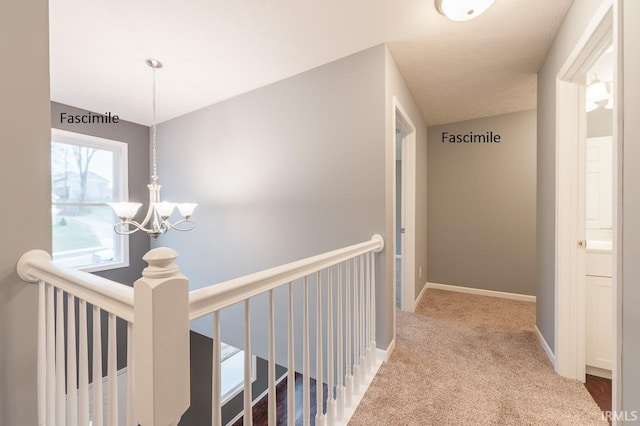hallway with baseboards, carpet, a chandelier, and an upstairs landing