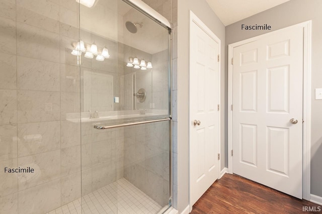 bathroom with wood finished floors and a stall shower