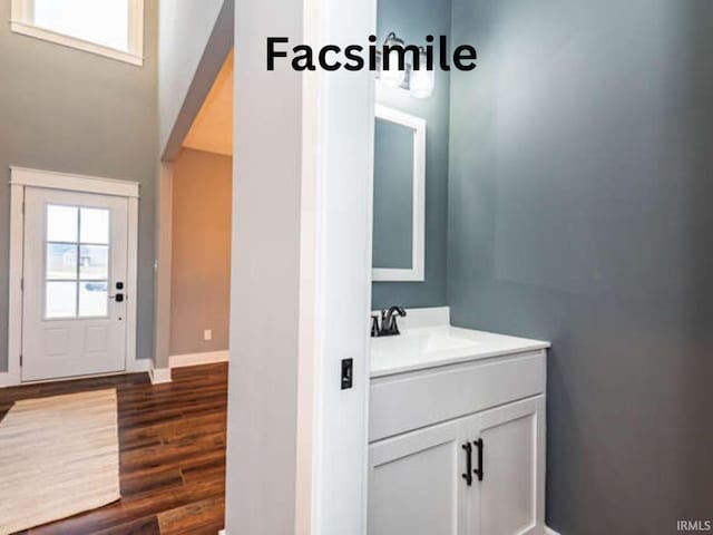 bathroom with baseboards, wood finished floors, and vanity