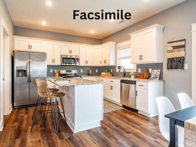 kitchen featuring a kitchen island, stainless steel appliances, and white cabinetry