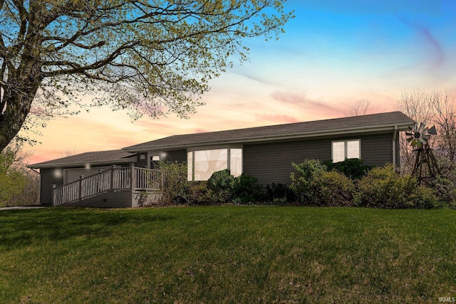 exterior space with a lawn, a wooden deck, and a garage