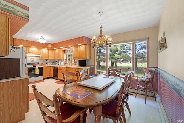 dining space with wallpapered walls, a notable chandelier, light floors, and a baseboard radiator
