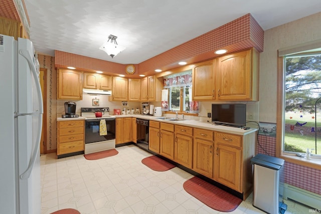 kitchen featuring a sink, electric stove, freestanding refrigerator, under cabinet range hood, and a baseboard heating unit