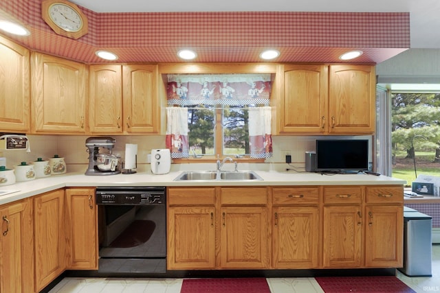 kitchen with a sink, light countertops, tasteful backsplash, and black dishwasher
