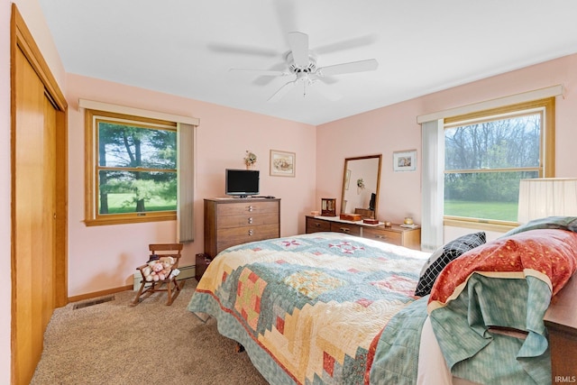 bedroom with carpet floors, a ceiling fan, baseboards, visible vents, and a closet