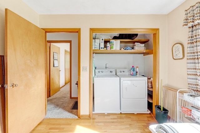 washroom with laundry area, light wood-type flooring, and washer and clothes dryer