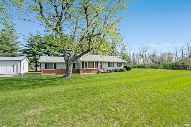 exterior space with an outbuilding, a front lawn, and brick siding