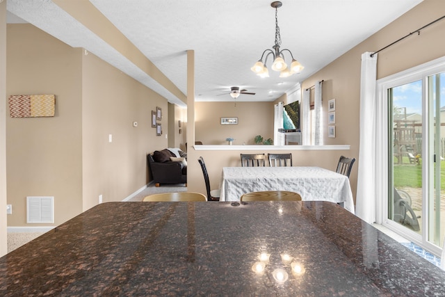 dining space with ceiling fan with notable chandelier and visible vents