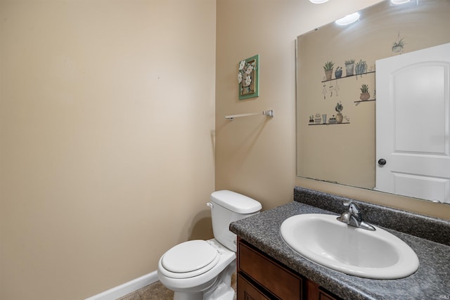 half bath featuring vanity, baseboards, and toilet