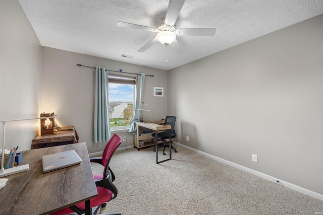 office featuring ceiling fan, a textured ceiling, visible vents, baseboards, and carpet flooring