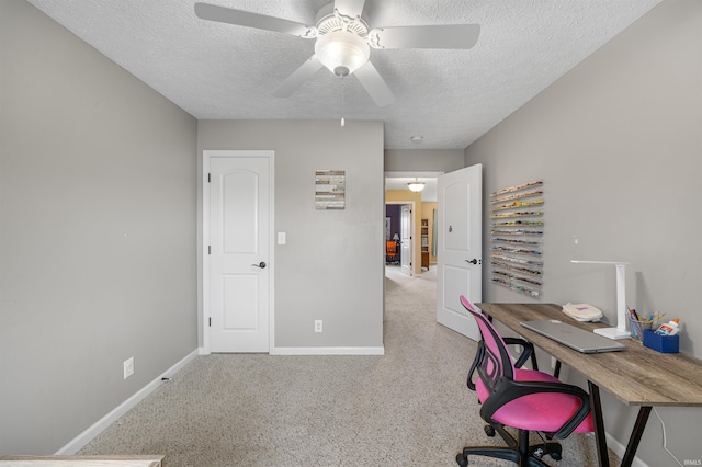 carpeted office with baseboards, a ceiling fan, and a textured ceiling