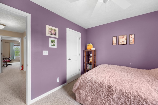 carpeted bedroom with a textured ceiling, ceiling fan, and baseboards