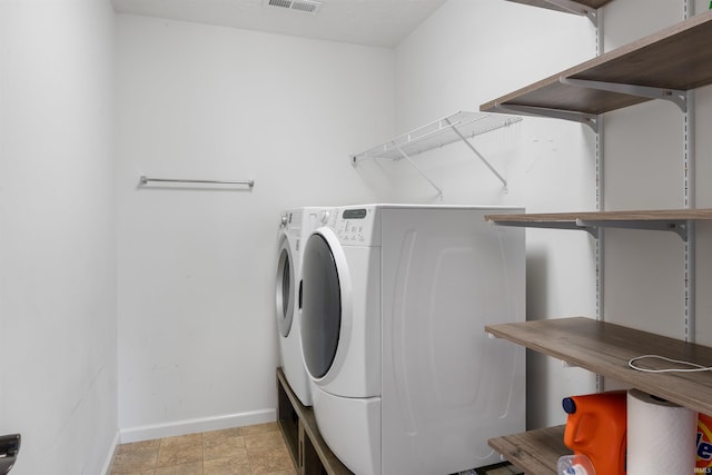 laundry room with laundry area, visible vents, washing machine and dryer, and baseboards