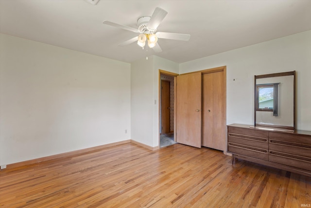 unfurnished bedroom featuring a closet, baseboards, a ceiling fan, and light wood-type flooring