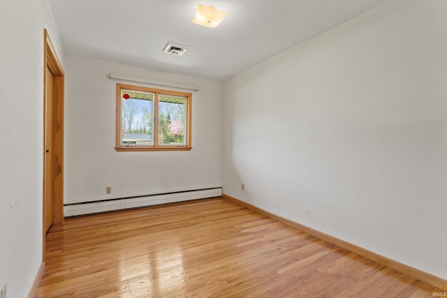 unfurnished bedroom with baseboards, a baseboard heating unit, light wood-type flooring, and visible vents