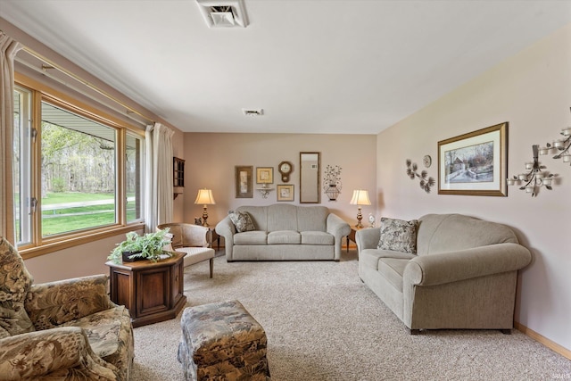 living area with light colored carpet, baseboards, and visible vents