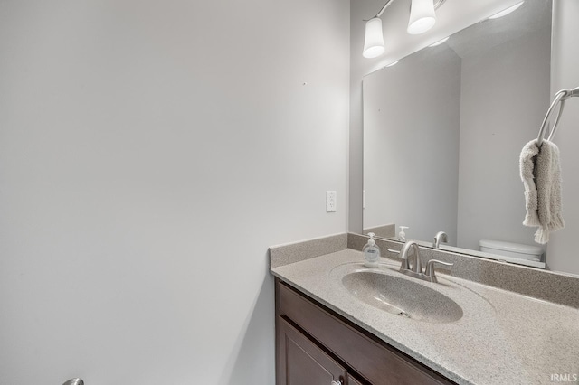 half bath featuring toilet and vanity