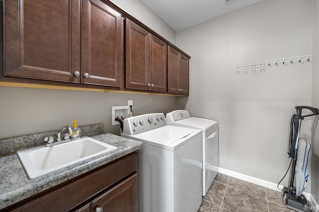 laundry room with baseboards, a sink, cabinet space, and washing machine and dryer