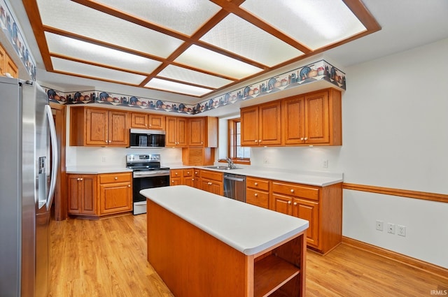 kitchen with light wood-type flooring, a sink, light countertops, and stainless steel appliances