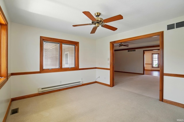 unfurnished room with visible vents, baseboards, a baseboard heating unit, and light carpet
