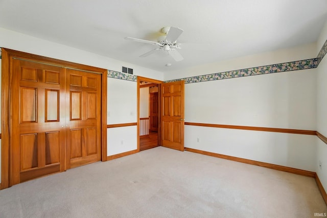 unfurnished bedroom with ceiling fan, visible vents, baseboards, a closet, and light carpet
