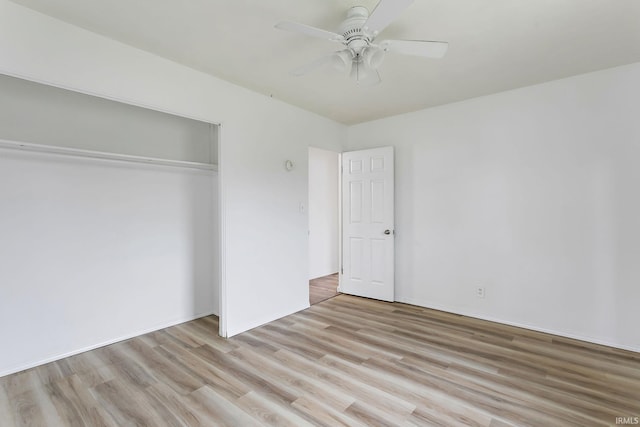 unfurnished bedroom with light wood-style floors, a ceiling fan, and a closet
